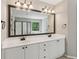 Bathroom featuring a double sink vanity with white cabinets, white countertop and a large framed mirror at 7020 Weybridge Dr, Cumming, GA 30040