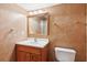 Cozy bathroom features a vanity with a mirror, a toilet, and warm toned walls at 7020 Weybridge Dr, Cumming, GA 30040