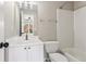 Bathroom features vanity sink, large mirror, and combo tub/shower with bright white tile and white cabinets at 7020 Weybridge Dr, Cumming, GA 30040