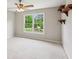 Bedroom features plush neutral carpet, a ceiling fan, and a bright view from the double windows at 7020 Weybridge Dr, Cumming, GA 30040