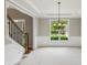 Dining room with a chandelier, white wainscoting, and a large window with views of the green outdoors at 7020 Weybridge Dr, Cumming, GA 30040