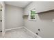 Empty laundry room with floating wood shelves and tile floors at 7020 Weybridge Dr, Cumming, GA 30040