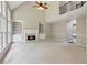 Bright living area featuring a fireplace, built-in shelving, high ceilings, and large windows with lush green views at 7020 Weybridge Dr, Cumming, GA 30040