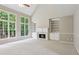 Bright living room with large windows, vaulted ceiling, fireplace, built-in shelving, and neutral color scheme at 7020 Weybridge Dr, Cumming, GA 30040