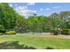 Well-maintained community tennis courts with lighting, surrounded by lush landscaping for an active lifestyle at 7020 Weybridge Dr, Cumming, GA 30040