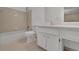 Bathroom with neutral tile floor and shower, white vanity, and white fixtures at 907 Country Park Se Dr, Smyrna, GA 30080
