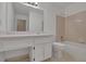 A bathroom with a vanity, toilet, and combined shower and tub with light-colored tile surround at 907 Country Park Se Dr, Smyrna, GA 30080