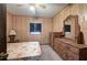 Cozy bedroom with a ceiling fan, wooden paneling, and traditional furnishings at 92 Valley Se Trl, Acworth, GA 30101