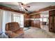 Open-concept living room with wood paneling, ceiling fan and sliding glass doors at 92 Valley Se Trl, Acworth, GA 30101