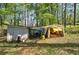 Storage shed in wooded backyard with blue tarp and assorted equipment at 92 Valley Se Trl, Acworth, GA 30101