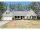 Charming single-story brick home with a well-manicured lawn, covered porch and attached two car garage at 1935 Knight Cir, Loganville, GA 30052