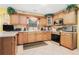 Well-lit kitchen featuring custom wood cabinets, appliances, and tile flooring at 1935 Knight Cir, Loganville, GA 30052