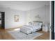 Bright bedroom featuring neutral paint, hardwood floors, modern lighting, and a decorative wall hanging at 2650 Fairoaks Rd, Decatur, GA 30033