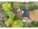 Aerial view of a home with a black roof, patio, driveway, RV, and mature trees on a large lot at 350 Spring View Ct, Dallas, GA 30157