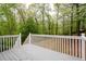Wide, green backyard with mature trees and gray deck with white railing at 350 Spring View Ct, Dallas, GA 30157