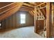 Unfinished attic room with window, exposed wood framing, and plywood flooring at 362 Mcgiboney Rd, Covington, GA 30016