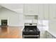 Open kitchen with stove, white cabinets, and view into the living area at 362 Mcgiboney Rd, Covington, GA 30016