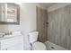 Updated bathroom showcasing a modern vanity, a toilet, and a walk-in shower with gray tile at 760 Woodrow Dr, Lawrenceville, GA 30043