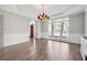 Elegant dining room with hardwood floors, a tray ceiling, a chandelier, and natural light from large window at 760 Woodrow Dr, Lawrenceville, GA 30043