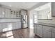 Bright kitchen featuring grey cabinets, granite counters and stainless steel refrigerator at 760 Woodrow Dr, Lawrenceville, GA 30043