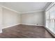 Bright and airy living room with hardwood floors, neutral paint, crown molding, and natural light from a large window at 760 Woodrow Dr, Lawrenceville, GA 30043