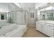 Bright bathroom featuring a large soaking tub, glass shower, and white vanity at 760 Woodrow Dr, Lawrenceville, GA 30043
