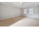 Spacious bedroom with carpet flooring, tray ceiling, and natural lighting at 760 Woodrow Dr, Lawrenceville, GA 30043