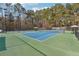 Tennis court featuring green and blue surface, net, lighting, and an Edgewater sign on the fence at 760 Woodrow Dr, Lawrenceville, GA 30043