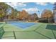 Community tennis court featuring green and blue surface, net, lighting, and perimeter fencing at 760 Woodrow Dr, Lawrenceville, GA 30043