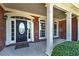 Inviting front porch with brick columns and a detailed front door, creating a warm entry at 7804 Gusty Trl, Douglasville, GA 30135