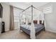 Bedroom featuring carpeted floors, white walls, and a canopy bed with a patterned quilt and white curtains at 245 Fairview Cir, Roswell, GA 30076