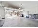 An open garage with a concrete floor, a view to townhomes, and storage for vehicles and equipment at 245 Fairview Cir, Roswell, GA 30076