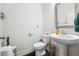 A clean powder room with a pedestal sink, toilet, and decorative mirror offers convenience for guests at 245 Fairview Cir, Roswell, GA 30076