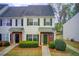 Charming townhome with manicured bushes, neutral siding, green shutters and door, and brick accents at 2758 Snapfinger Mnr, Decatur, GA 30035