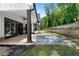 A backyard featuring a covered patio with an outdoor seating area, beautiful stone tile and green lawn at 120 Farm Gate Dr, Woodstock, GA 30188
