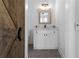 Elegant half bath with modern vanity and rustic barn door at 120 Farm Gate Dr, Woodstock, GA 30188
