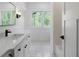 Bright bathroom featuring double windows, white cabinets and modern fixtures at 120 Farm Gate Dr, Woodstock, GA 30188