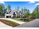 A serene exterior view with a long driveway, lush green lawn, and beautifully landscaped front yard at 120 Farm Gate Dr, Woodstock, GA 30188