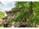 Exterior view of home with mature trees, a wood facade and private balconies at 2109 Defoors Ferry Nw Rd # D, Atlanta, GA 30318