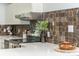 Kitchen featuring white quartz countertops, range hood, and a decorative tile backsplash at 2109 Defoors Ferry Nw Rd # D, Atlanta, GA 30318