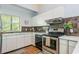 Well-lit kitchen with white cabinets, quartz countertops, stainless steel appliances, and decorative tile backsplash at 2109 Defoors Ferry Nw Rd # D, Atlanta, GA 30318