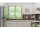 Kitchen sink with a view, white cabinets, quartz countertops, stainless steel refrigerator, and decorative tile backsplash at 2109 Defoors Ferry Nw Rd # D, Atlanta, GA 30318