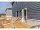 Wooden deck with blue siding, a white brick base, and a white door providing outdoor access at 342 Orwell Dr, Social Circle, GA 30025