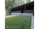 Backyard featuring artificial grass and a dark covered patio with lighting at 3572 Adkins Nw Rd, Atlanta, GA 30331