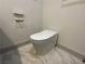 Modern, elongated white toilet with sleek design and marble flooring at 3572 Adkins Nw Rd, Atlanta, GA 30331