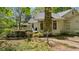 Rear exterior view of the home showing a stone chimney, deck, and lush green landscape at 5251 Powers Ferry Rd, Atlanta, GA 30327