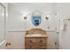 Charming half bathroom featuring vanity, mirror, stylish sconces, wainscoting, and neutral tones at 5251 Powers Ferry Rd, Atlanta, GA 30327