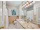 Bright bathroom with a granite countertop, tan walls, and window with shuttered shades at 5251 Powers Ferry Rd, Atlanta, GA 30327