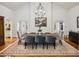 Elegant dining room featuring hardwood floors, a striking chandelier, and a large table with seating for eight at 5251 Powers Ferry Rd, Atlanta, GA 30327