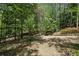 A gravel driveway leads to the home surrounded by shade trees at 5251 Powers Ferry Rd, Atlanta, GA 30327
